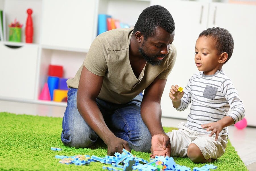 providers-father-son Man playing on the floor with boy