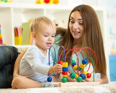 Mujer y niño juegan en el suelo